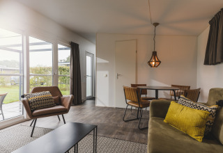 Knusse leefruimte in een Cosy Cabin op Vakantiepark Hölte in Nederland, modern ingericht met veel daglicht.
