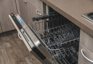 Open dishwasher in a modern kitchen at Cosy cabin, Vakantiepark Hölte, Netherlands, ready for loading.