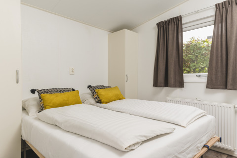 Bedroom in Cosy cabin at Vakantiepark Hölte, Netherlands, with two single beds and bright decor.