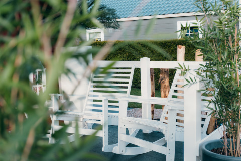 Panchine bianche e piante verdi al Veluwe lounge + sauna presso Holiday park De Boshoek, Paesi Bassi.