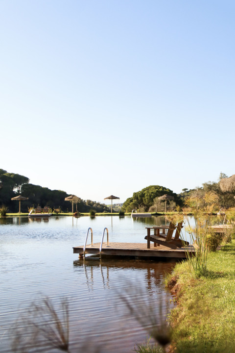Vlonder en stoelen aan het meer bij Dome House Duplex Do Lago, Wecamp Reserva Alecrim, Portugal op een zonnige dag.