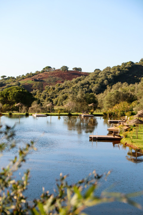 Rustig meer met houten steigers bij Dome House Duplex Do Lago, Wecamp Reserva Alecrim, Portugal.