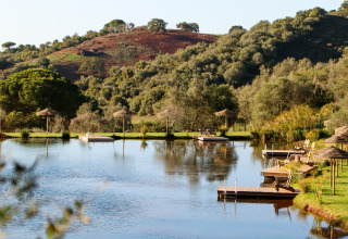 Rustig meer met houten steigers bij Dome House Duplex Do Lago, Wecamp Reserva Alecrim, Portugal.