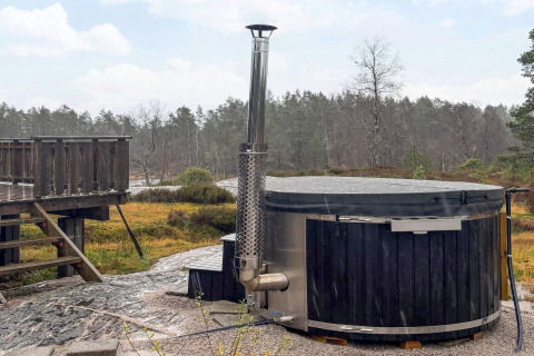 Udendørs spabad med trædæk ved hytten 76409 TROLLHYTTA omgivet af dansk natur og skov.