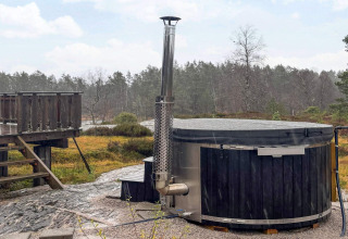 Udendørs spabad med trædæk ved hytten 76409 TROLLHYTTA omgivet af dansk natur og skov.