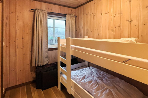 Et hyggeligt værelse med køjesenge, træpaneler og store gardiner på en lodge i Danmark kaldet 76409 TROLLHYTTA.