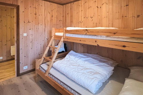 Værelse med køjeseng i træ og lyse trævægge på TROLLHYTTA lodge i Danmark, hyggelig atmosfære.