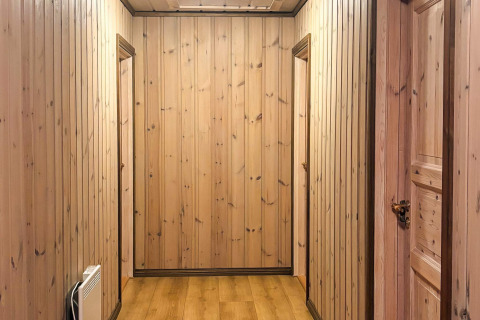 Gang med træpaneler og døre i en lodge kaldet 76409 TROLLHYTTA, taget i Danmark.