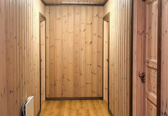 Couloir avec des panneaux en bois et des portes à la lodge 76409 TROLLHYTTA, prise au Danemark.