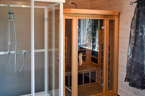 Moderne badeværelse i 76409 TROLLHYTTA-lodge, Danmark, med brusekabine og infrarød sauna.