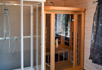Salle de bain moderne au lodge 76409 TROLLHYTTA au Danemark, avec douche et sauna infrarouge.