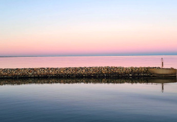 Stenmur ved vandet under en lyserød og blå himmel ved Seaside Bliss i albaek, Danmark, ved solnedgang.