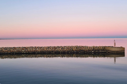 Stenmur ved vandet under en lyserød og blå himmel ved Seaside Bliss i albaek, Danmark, ved solnedgang.