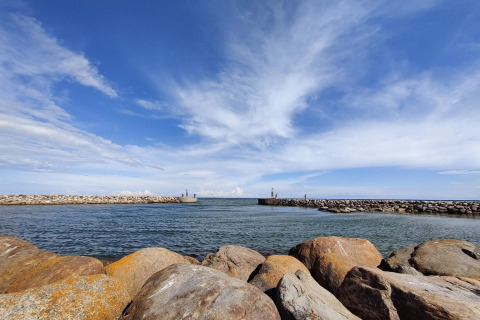 Vista del mar y el cielo desde Seaside Bliss en Albaek, Dinamarca, con grandes rocas en primer plano.