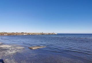 Uitzicht op zee vanaf het strand bij Seaside Bliss in Albaek, Denemarken, met een blauwe lucht.