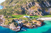 Vista aérea de Engvik Hytta, cabañas junto al mar, agua turquesa, playa y colinas verdes en Suecia.