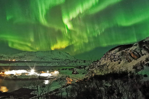 Aurora boreale sopra montagne innevate e la cabina Engvik Hytta 83699 in Svezia, fotografia notturna.