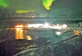 Noorderlicht boven besneeuwde hut bij ENGVIK HYTTA 83699 in Zweden, met lichtreflecties op het water.