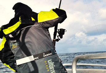 Iemand met een 'TEAM Atlantic Race'-jas vist vanaf een boot bij ENGVIK HYTTA 83699 in Zweden.