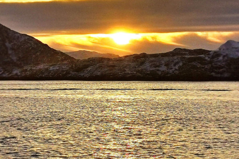 Tramonto visto da Engvik Hytta 83699, Svezia, con montagne innevate e lago dorato riflettente.