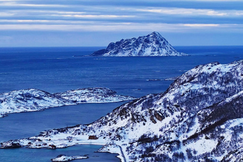 Vista da Engvik Hytta 83699 in Svezia, montagne e isole innevate circondate dal mare blu e dal cielo.