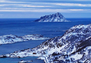 Vista da Engvik Hytta 83699 in Svezia, montagne e isole innevate circondate dal mare blu e dal cielo.