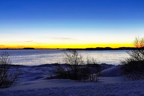 Splendido tramonto sulla riva innevata visto dalla cabina Engvik Hytta 83699 in Svezia, vicino all’acqua.