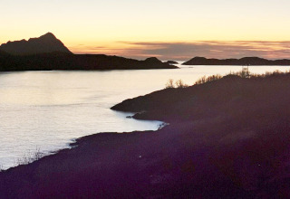 Zonsondergang vanaf Engvik Hytta 83699 in Zweden met silhouetten van heuvels en een kalm meer.