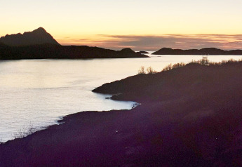 Zonsondergang bij Engvik Hytta 83699 in Zweden, met silhouetten van heuvels en een rustig meerlandschap.