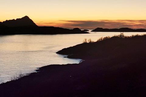 Tramonto a Engvik Hytta 83699 in Svezia, con colline silhouette e paesaggio lacustre tranquillo.