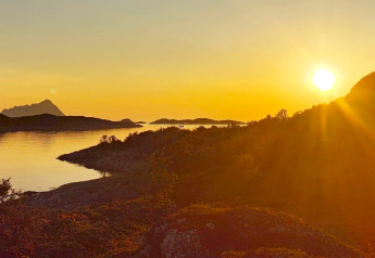 Zonsondergang boven bergen en water vanaf Engvik Hytta 83699 in Zweden, met een gouden licht.