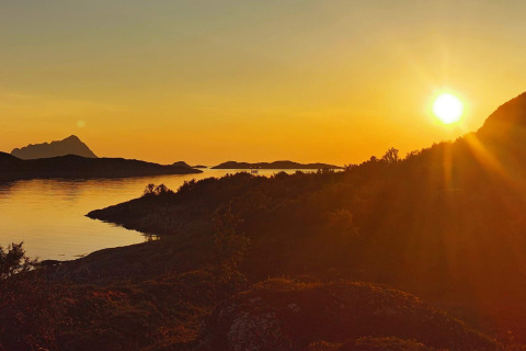 Tramonto su montagne e acqua dalla cabina Engvik Hytta 83699 in Svezia, bagliore dorato sul paesaggio.