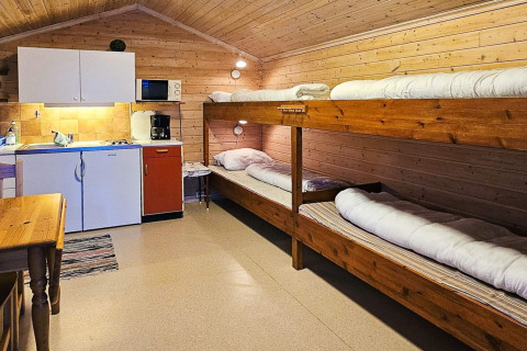 Vista interna della cabina Engvik Hytta 83699 in Svezia con cucina e letti a castello in legno.