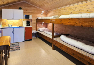 Vista interna della cabina Engvik Hytta 83699 in Svezia con cucina e letti a castello in legno.