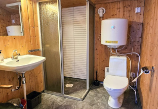Bagno rustico con pareti in legno, doccia, WC e scaldabagno in ENGVIK HYTTA 83699, Svezia.