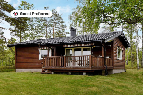 Træhytte med terrasse omgivet af natur i Frändefors, Sverige, ideel til en ferie for fire personer.