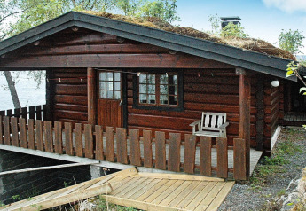 Blockhütte mit Grasdach und Terrasse, 4-Personen-Ferienhaus am Wasser in Surna.