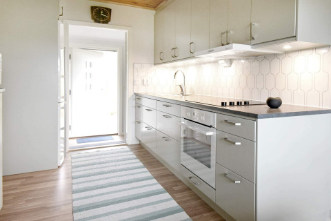 Lichte moderne keuken in een vakantiehuis voor 4 personen in Frändefors, Zweden, met witte kasten en vloer.