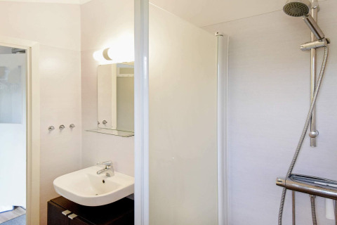Badezimmer in einem 4-Personen-Ferienhaus in Frändefors, Schweden, mit Waschbecken und Dusche.