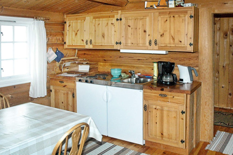 Cuisine en bois dans une maison de vacances pour 4 personnes à Surna, Suède, avec table et cafetière.