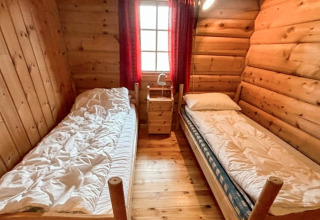 Hyggeligt træbeklædt soveværelse i chalet “4 person holiday home in Surna” med to enkeltsenge i Sverige.