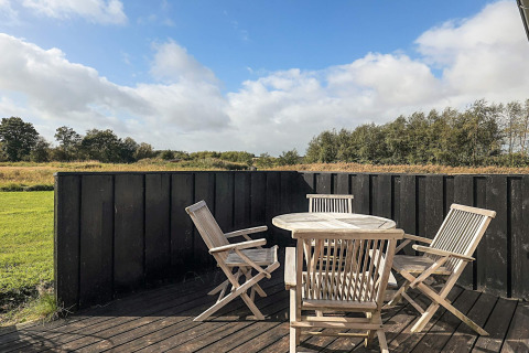 Terraza exterior con mesa y sillas de madera en casa vacacional para 6 personas en Øster Assels, Dinamarca, naturaleza.