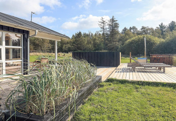 Terrasse extérieure d’une maison de vacances à Øster Assels, Danemark, avec transat et verdure.