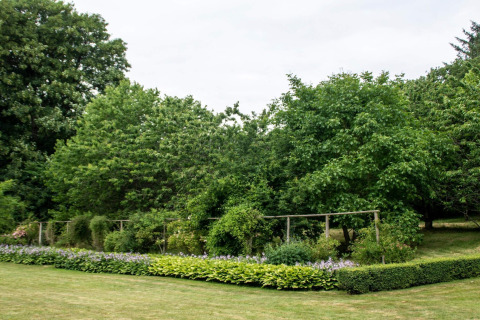 Vista de jardín en casa de vacaciones para 6 personas en Øster Assels, Dinamarca, con árboles y césped.
