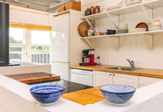 Helles Ferienhaus-Küche in Øster Assels, Dänemark, mit Holzarbeitsplatte und offenen Regalen.
