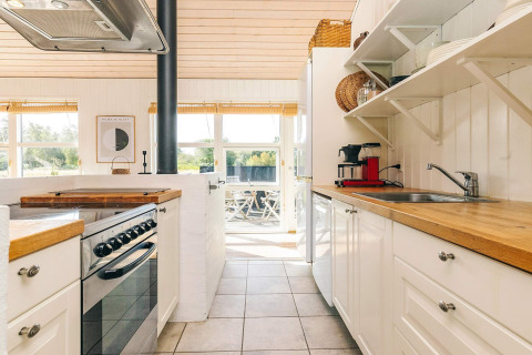 Cucina luminosa in casa vacanze per sei persone a Øster Assels, Danimarca, con piani in legno.