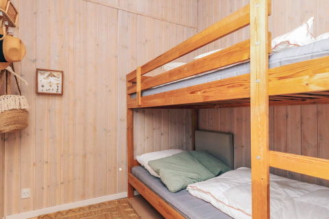 Habitación con litera de madera y paredes de panel en casa de vacaciones para 6 personas en Øster Assels, Dinamarca.