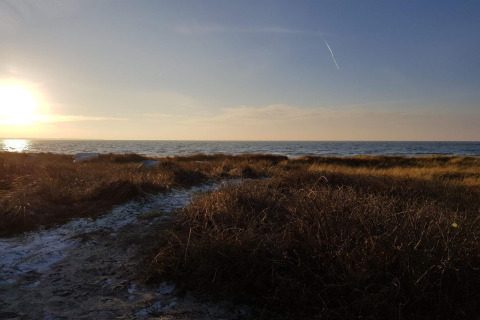 Solnedgang over havet set fra græsarealet ved feriehus for 6 personer i Store Fuglede, Danmark.