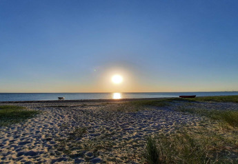 Sonnenuntergang am Strand beim '6 Personen Ferienhaus in Store Fuglede', Dänemark, mit Boot.