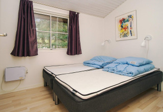 Slaapkamer in 6-persoons vakantiehuis in Store Fuglede, Denemarken, met twee bedden en blauwe dekbedden.